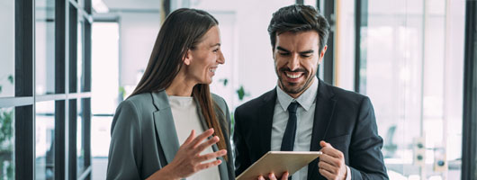 dos trabajadores contentos mirando una tablet