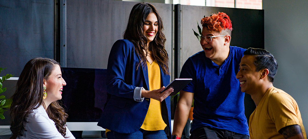 Grupo de trabajadores riéndose en una oficina 