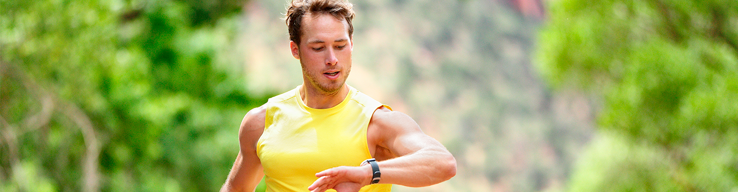 Corredor mirando su reloj mientras corre