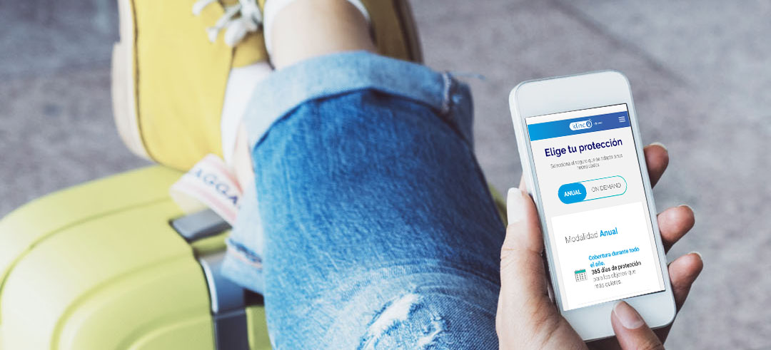 Persona con los pies encima de una maleta y en su móvil la protección de un seguro de Zurich