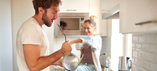 joven pareja cantando en la cocina
